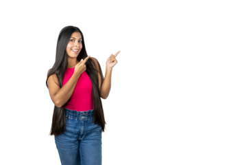 Smiling Mexican Woman with Long Hair Pointing to the Right on a White Background. Wearing a Pink Shirt and Blue Jeans