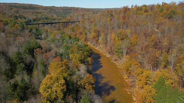 Aerial view of historic railroad bridge crossing a river valley, drone 4K
