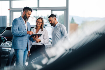Digital consultation on car purchases in a sunlit showroom.