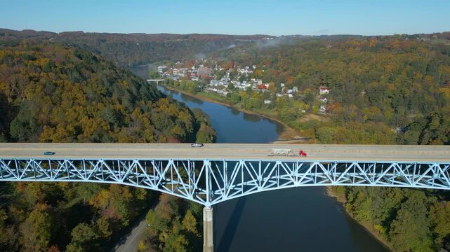 Aerial view of a small town on the mountainside with beautiful Fall foliage and fog, drone 4K