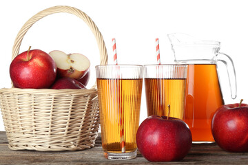 Tasty apple juice in glasses, jug and fresh fruits on wooden table against white background