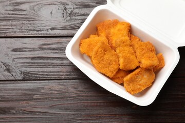 Tasty chicken nuggets on wooden table, top view. Space for text