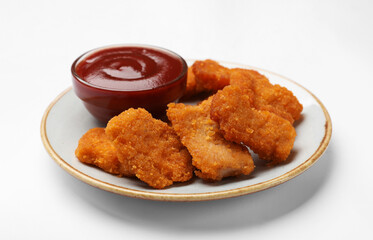 Delicious chicken nuggets with ketchup on white background