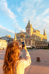 Obraz premium girl takes photo on morning central square of batumi in georgia in summer at dawn