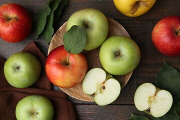 Different ripe apples on wooden table, flat lay