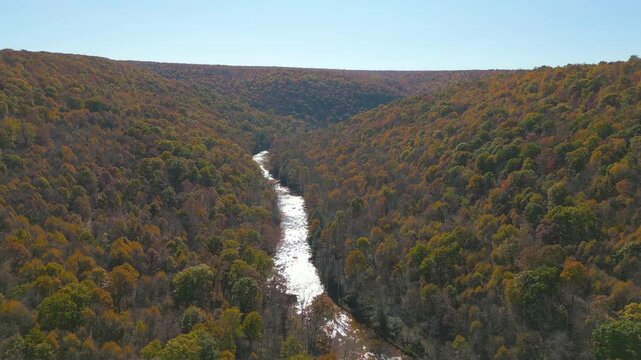 Aerial view of a serene river valley in Autumn, drone 4K
