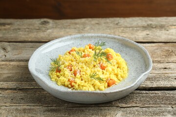Delicious pumpkin risotto on wooden table, closeup