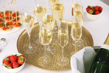 Champagne, strawberries and canapes with red caviar on white table