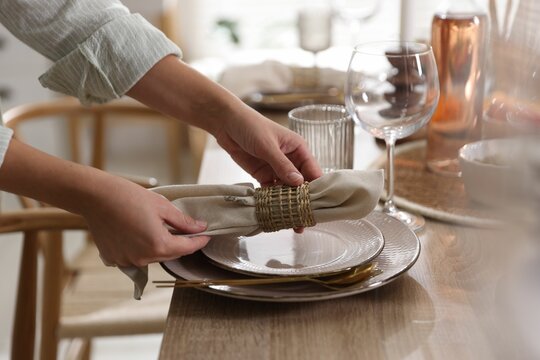 Woman setting table for dinner at home, closeup - Powered by Adobe