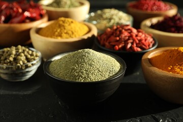 Different aromatic spices on black table, closeup