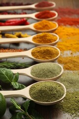 Different aromatic spices and herbs on wooden table, closeup