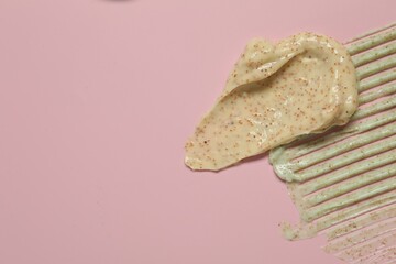 Samples of different body scrubs on pink background, top view. Space for text