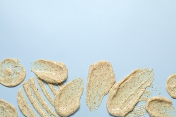 Samples of body scrub on light background, flat lay. Space for text