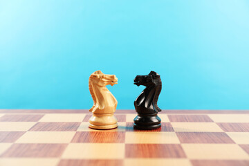 Black and white chess knights in middle of chessboard. Competition concept