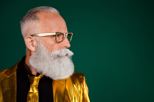 Elegant elderly man with a beard in a glamorous golden suit against a vibrant green background, showcasing retro fashion and charisma