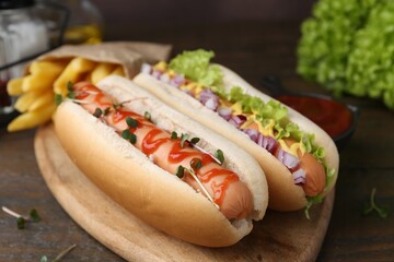 Tasty hot dogs served on wooden table, closeup