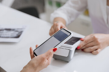 Contactless smartphone payment at a clinic reception desk for a seamless transaction