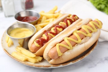 Tasty hot dogs with fries served on white marble table, closeup