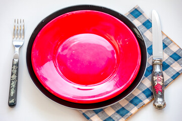 Colorful Empty plate isolated on white background with rustic cutlery set next to it