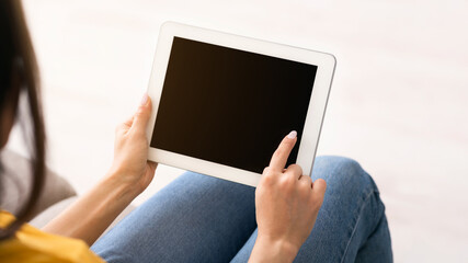 Stay home, chat online. Unrecognizable girl holding tablet computer with empty screen indoors, space for design