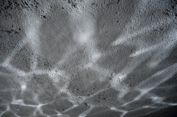 Fototapeta premium Concrete wall with light shiny stripes reflected from water. Contemporary background.