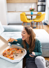 Girl eating pizza while watching tv at home