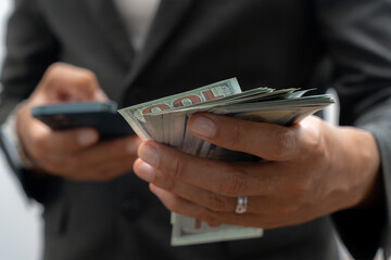 Man hand with a stack of hundred US dollars bills