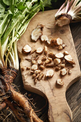 Sliced fresh dandelion root on a table - preparation of herbal tincture © Madeleine Steinbach