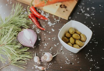 Fresh red salmon on a wooden tray with pepper, salt, garlic, red onion, red pepper, olives with jam
