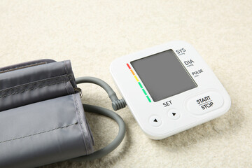 Blood pressure measuring device on light textured background, closeup