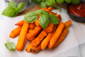 Sweet potato fries and basil on table, closeup