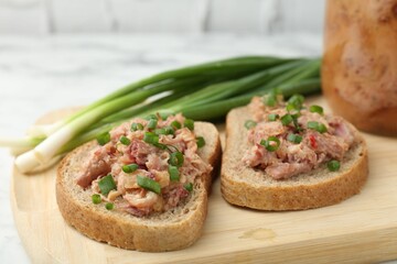 Sandwiches with canned meat and green onions on table, closeup
