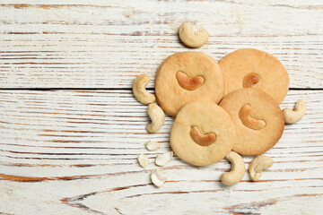 Tasty cashew cookies on rustic wooden table, flat lay. Space for text
