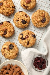 Delicious oatmeal cookies with raisins and nuts on white marble table, flat lay