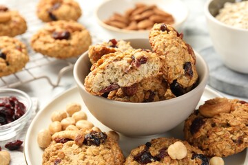 Delicious oatmeal cookies with raisins and nuts on table, closeup