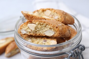 Traditional Italian almond biscuits (Cantucci) in jar on white table, closeup