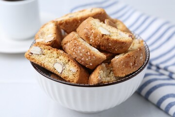Traditional Italian almond biscuits (Cantucci) in bowl on white table, closeup