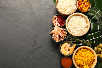 Cut banana leaves with different food and sauce on dark textured table, flat lay. Space for text