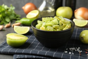 Delicious salsa (Pico de gallo) in bowl and products on grey table, closeup