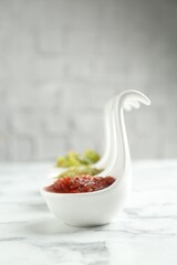 Sauce boats with salsa on white marble table, selective focus. Space for text
