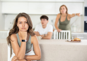 Young girl listens to swearing and accusations of inappropriate behavior from mother and older...
