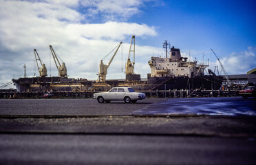 A vintage photo a ship at the dockside with a car