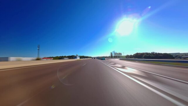 Timelapse of road drive along the highway. Front view to the road and surrounding landscapes. Trees stretch on both sides of road. Fast car hyperlapse. Road trip travel concept sort of dashcam POV