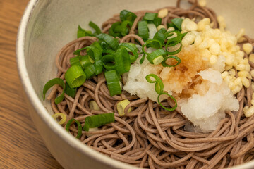 ネギと大根おろしがのせられた冷たい蕎麦