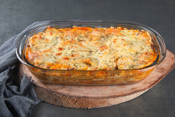 Lasagna with melted cheese on a gray background