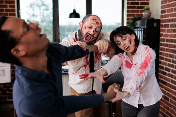 Possessed zombie creatures in business office grabbing worker, trying to eat his flesh. Bloody...