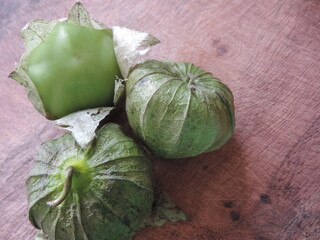Tomates verdes con cáscara sobre una tabla de madera
