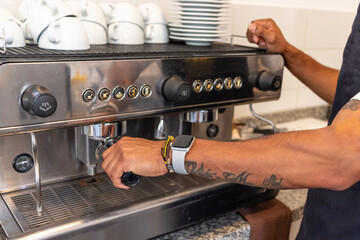 Barista preparing coffee with professional machine in coffee shop