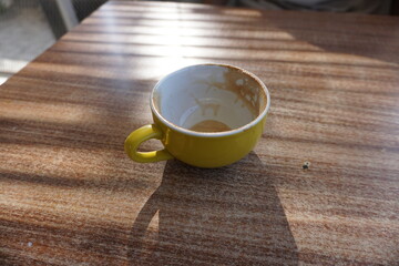 Empty coffee cup after drink on wood table. Empty cup of coffee with coffee stain after finish drinking.