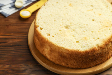 Tasty cut sponge cake on wooden table, closeup